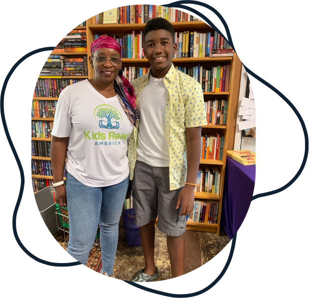 Photo of KidsReadAmerica founder, Zebrinia, with teen in font of a book shelve.