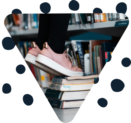 Feet on tip-toes on top of books in a library in a triangle frame surrounded by marker dots.